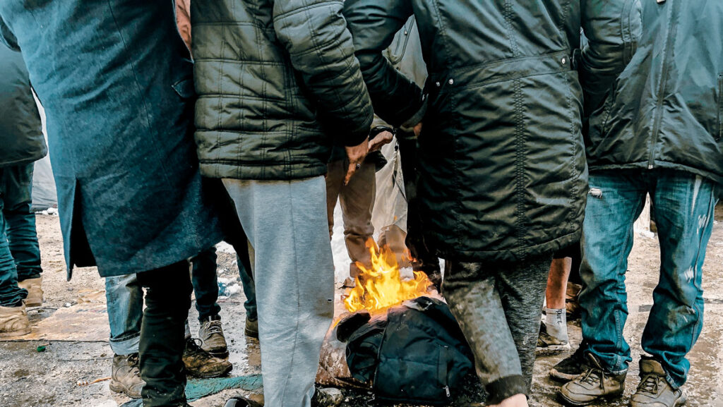 Eine Gruppe von Menschen, in deren Mitte brennt ein Klamottenstück.