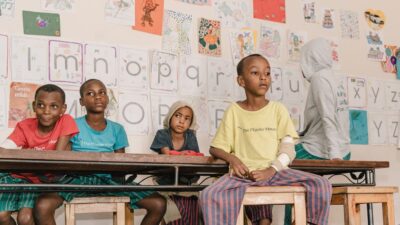 Kinder in Tansania, die in einem Raum sitzen.