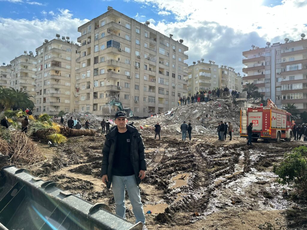 Serkan vor einem Trümmerhaufen nach den verheerenden Erdbeben in der Türkei.