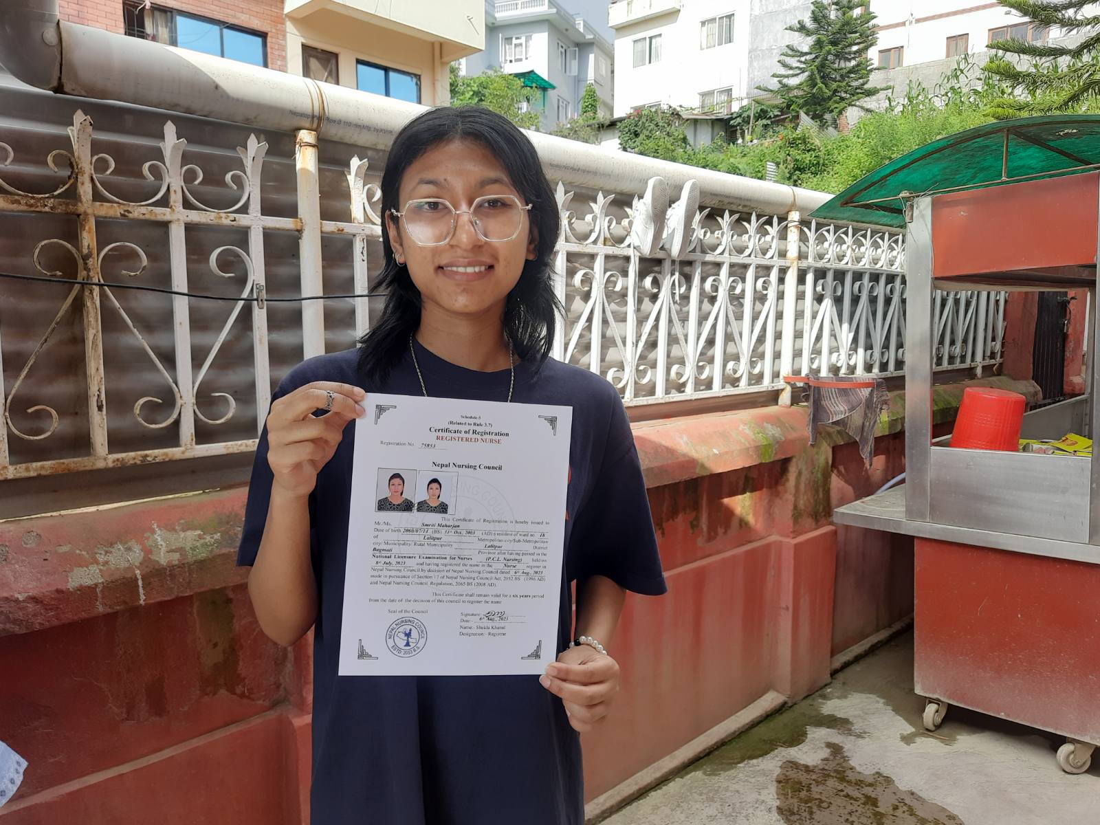Ein Mädchen aus Nepal hält ihr Abschlusszertifikat in den Händen.