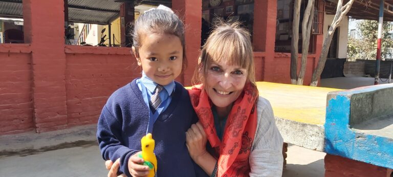 Gaby, unsere Supporterin on Site in Nepal, mit einem kleinen Kind aus Nepal.