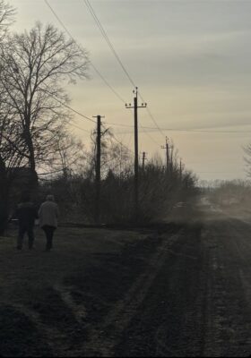 Ein Pärchen, das auf einem verstaubten und sonst menschenleeren Stück Land in der Ukraine läuft.