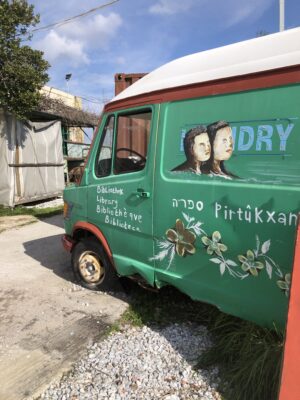 Auf dem Bild ist ein grüner Bus auf Lesbos zu sehen, der eine etwas andere Bücherei sein soll.