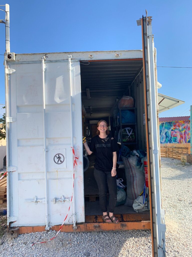 Volunteer Svenja vor einem Spendencontainer.