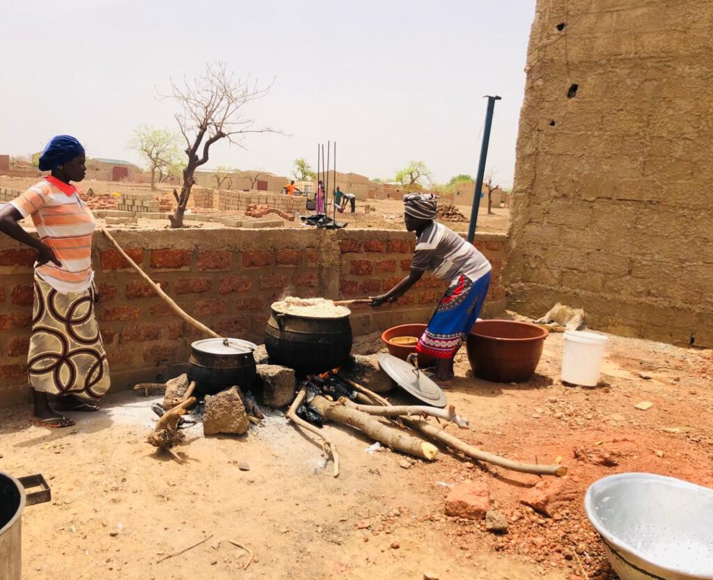 Zwei Frauen in Burkina Faso kochen zusammen.